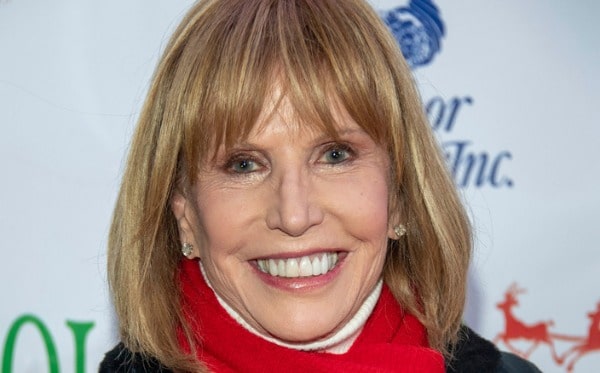 Photo of Leslie Charleson wearing diamond earrings and red scarfs 